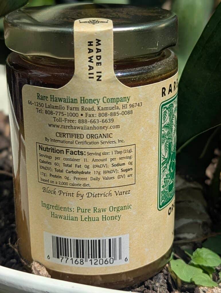 Pure raw organic Hawaiian Lehua honey in glass jar with label details.